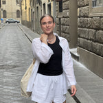 Kvinde i åben hvid oversized skjorte i hør