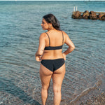 Kvinde i behagelig sort bikini underdel der dækker balderne