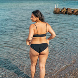 Kvinde i behagelig sort bikini underdel der dækker balderne