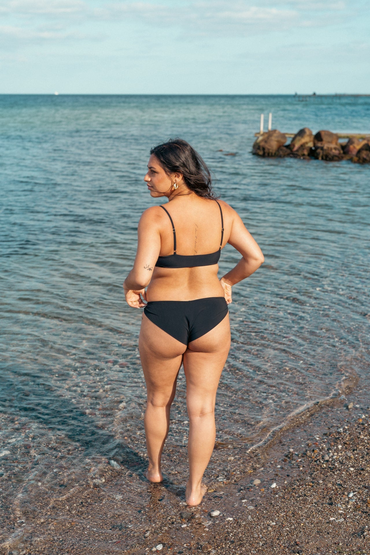 Kvinde i behagelig sort bikini underdel der dækker balderne
