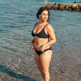 Kvinde i sort støttende bikini bund til strand