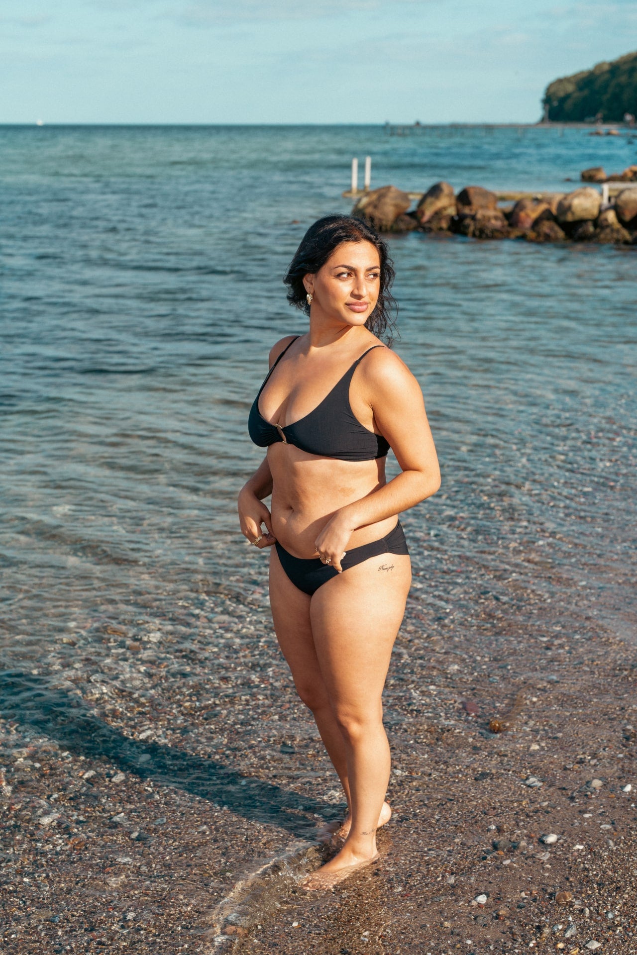 Kvinde i sort støttende bikini bund til strand