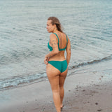 Kvinde i grøn bikiniunderdel på stranden