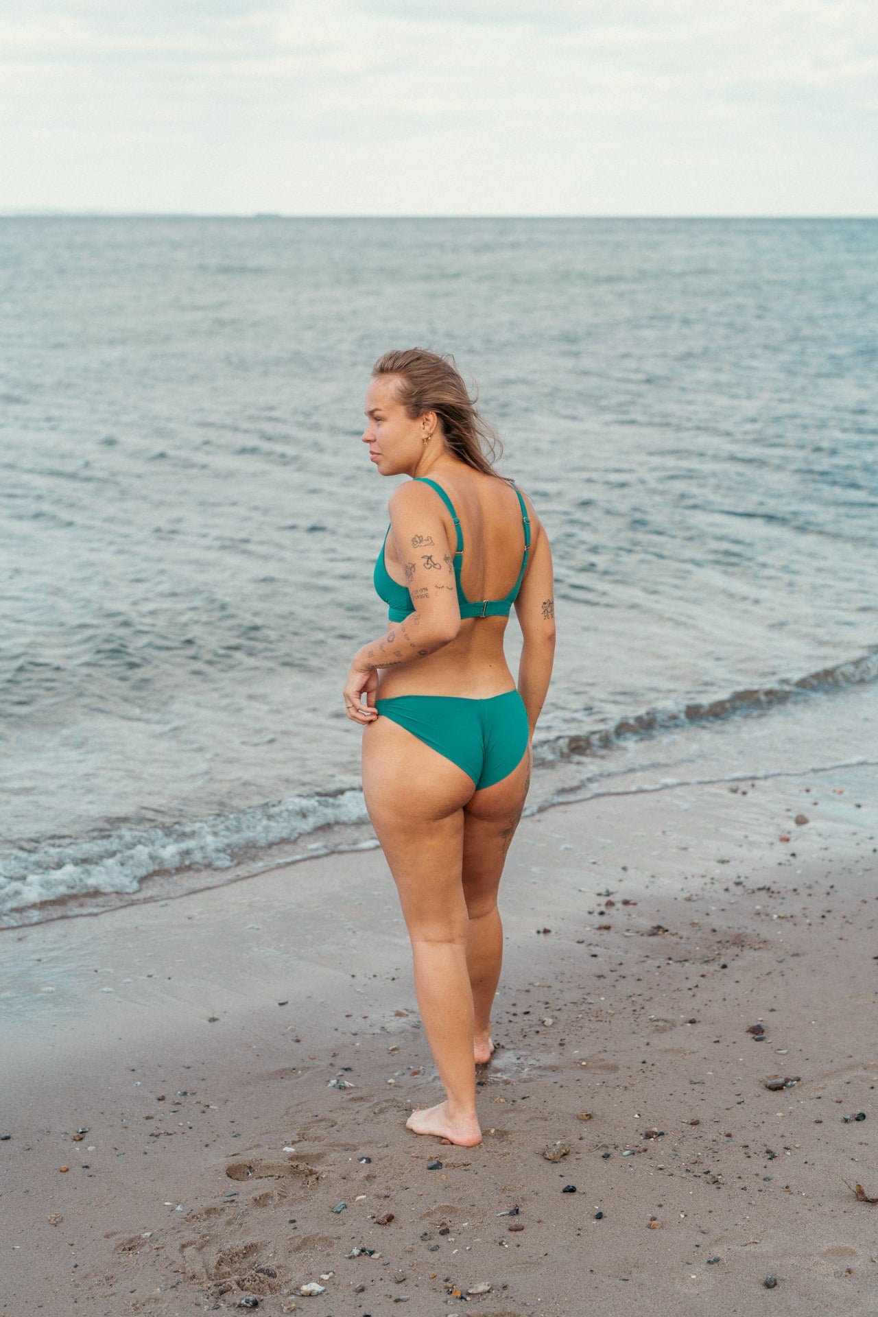 Kvinde i grøn bikiniunderdel på stranden
