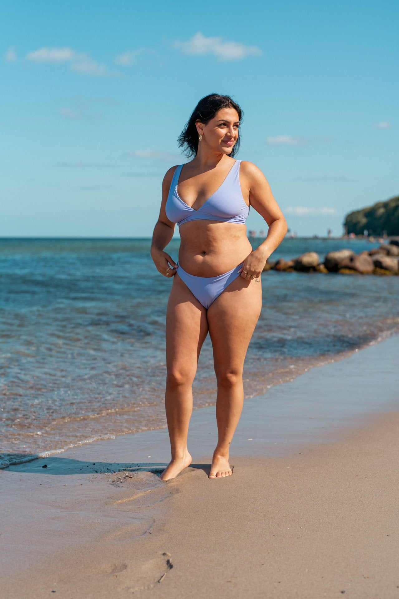 Kvinde i cheeky lilla bikini bund på stranden