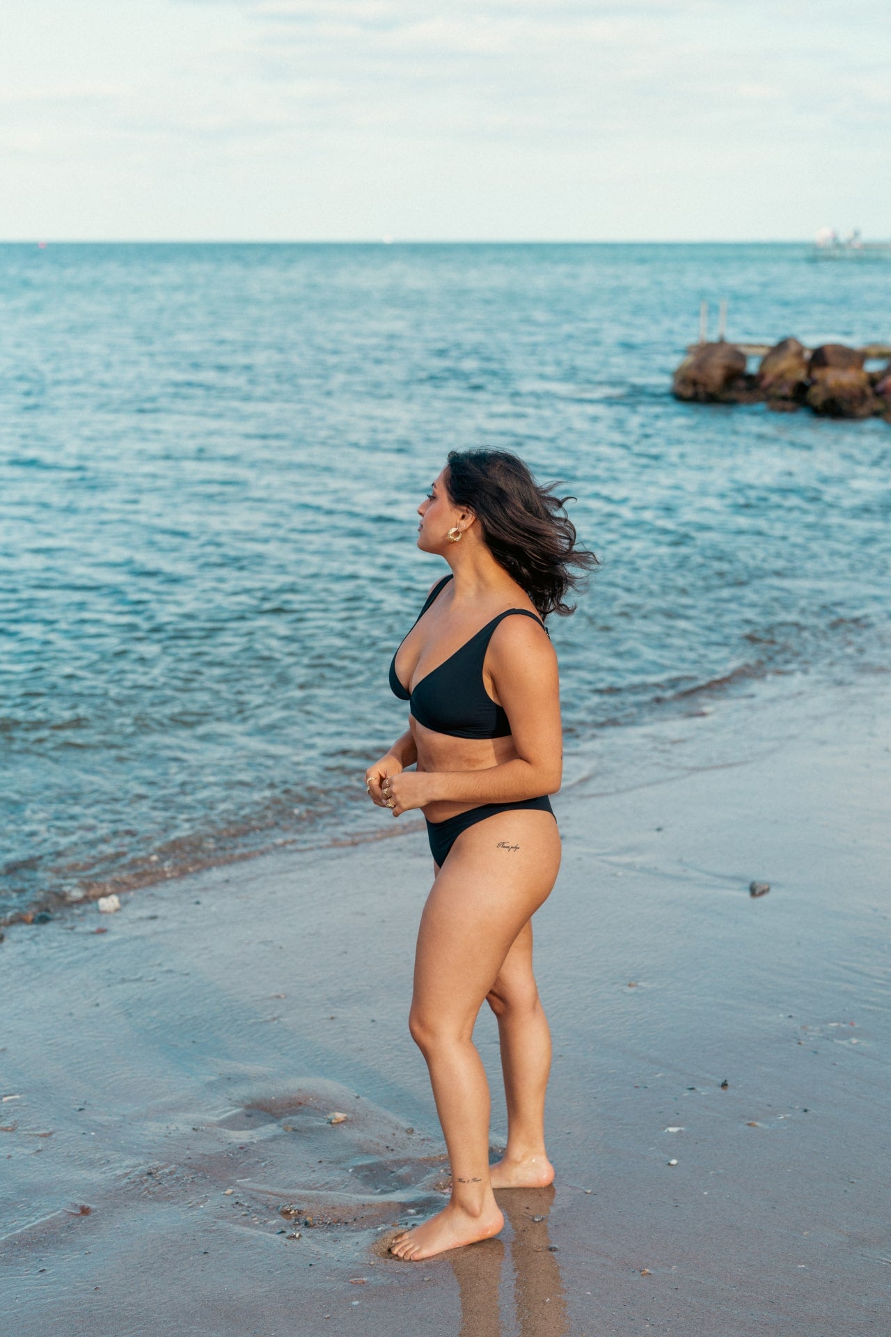 Kvinde i behagelig sort bikini på stranden