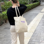 Kvinde med stor beige strandtaske
